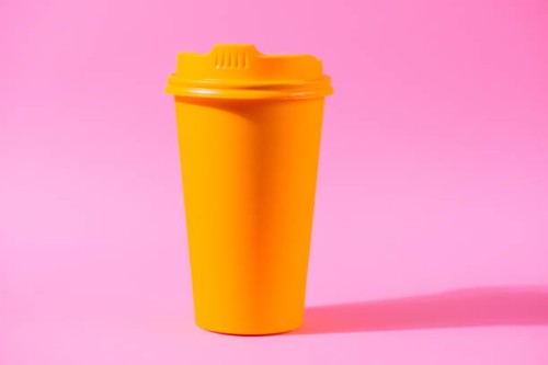 yellow coffee cup against colorful pink background - junk food stock pictures, royalty-free photos & images