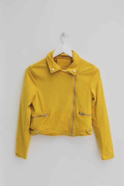 yellow jacket hung on rack in diy fashion studio workshop space - fashion stock-fotos und bilder