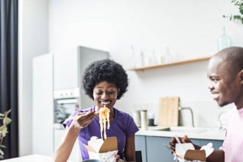 young adult black couple eating take out wok - junk food stock pictures, royalty-free photos & images