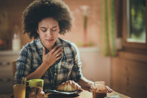 young african american woman feeling nausea during breakfast time at dining room. - food stock pictures, royalty-free photos & images