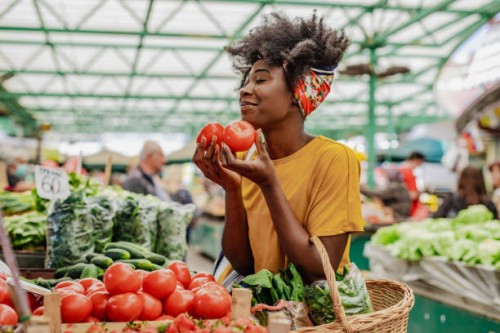 young african woman buying tomatoes at the market - food stock pictures, royalty-free photos & images