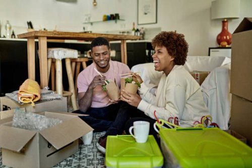 young afro-caribbean couple enjoying take-out on moving day - junk food stock pictures, royalty-free photos & images