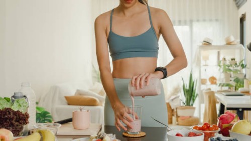 young asian athletic woman using blender and pouring smoothie to glass at home. healthy food. - food stock pictures, royalty-free photos & images