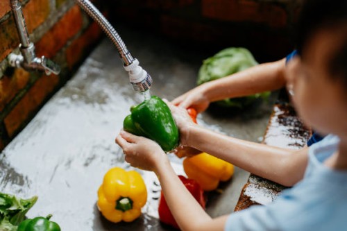 young asian boy and girl washing fresh vegetables - food stock pictures, royalty-free photos & images