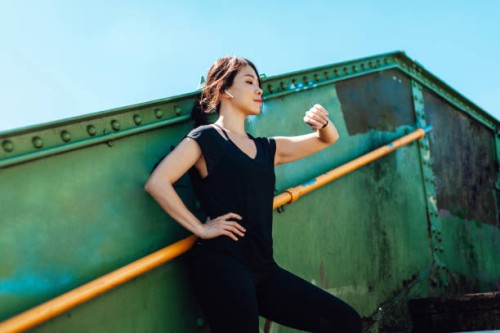young asian female runner checking smart watch while taking a break - fashion stock pictures, royalty-free photos & images