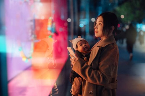 young asian mother using smartphone while doing christmas shopping with her daughter - fashion stock pictures, royalty-free photos & images