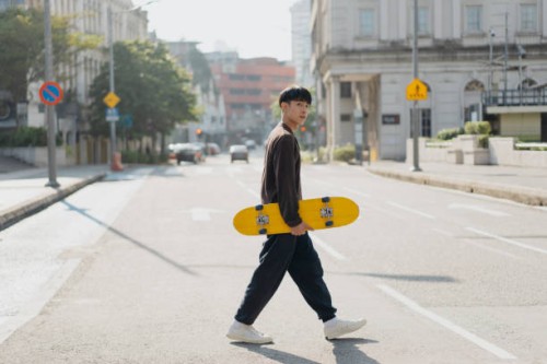 young asian skateboarder walking on the street - fashion stock pictures, royalty-free photos & images