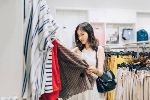 young asian woman choosing new clothes in the clothing store. - fashion stock pictures, royalty-free photos & images