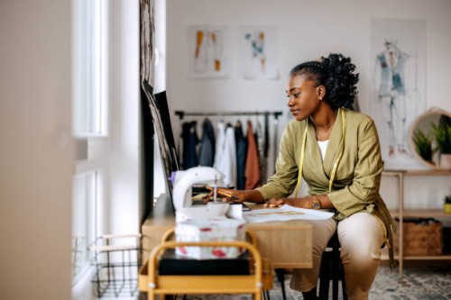 young beautiful female clothing designer drawing sketches at workshop - fashion stock pictures, royalty-free photos & images