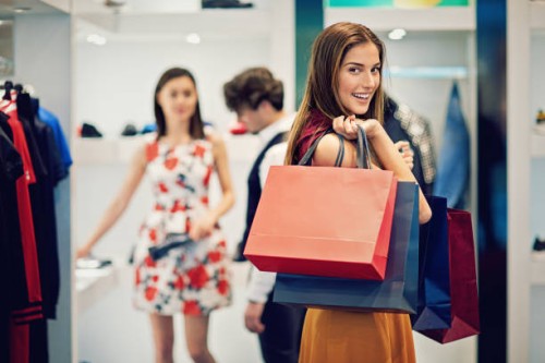 young beautiful girl is possing with her shopping bags in a boutique - fashion stock pictures, royalty-free photos & images