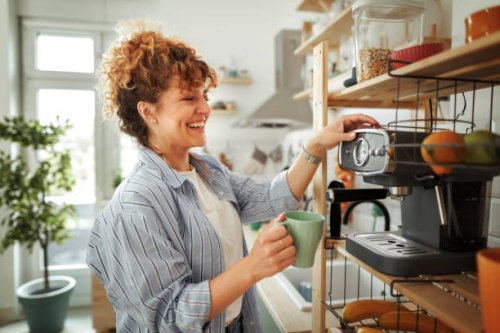 young beautiful smiling woman making coffee in a domestic kitchen - coffee stock pictures, royalty-free photos & images