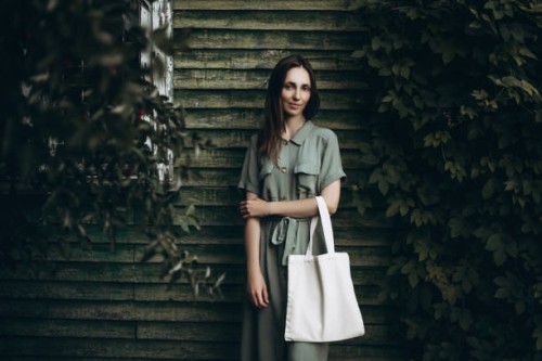 young beautiful woman in a green dress with a white eco bag - fashion stock-fotos und bilder