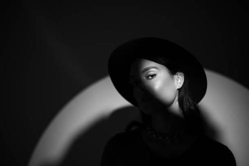 young beautiful woman portrait in round hat with shadow on her face - stock photo - fashion stock pictures, royalty-free photos & images