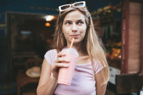 young blonde woman drinking strawberry smoothie,chiang mai,thailand - junk food stock pictures, royalty-free photos & images