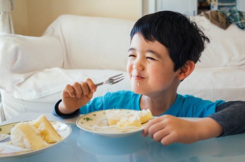 young boy eating a slice of cake - junk food stock pictures, royalty-free photos & images