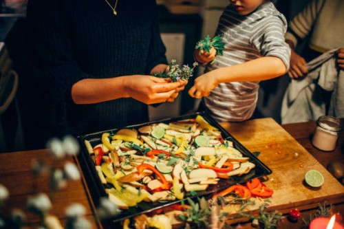 young boy sprinkling fresh herbs on vegetable dish - home decoration stock pictures, royalty-free photos & images