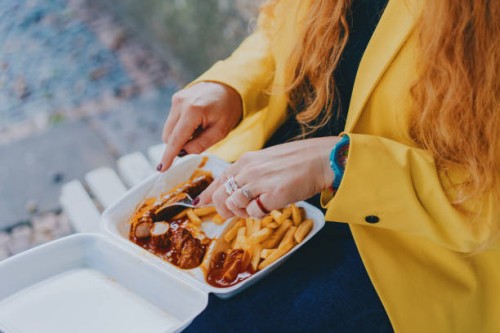 young businesswoman eating french fries at public park - junk food stock pictures, royalty-free photos & images
