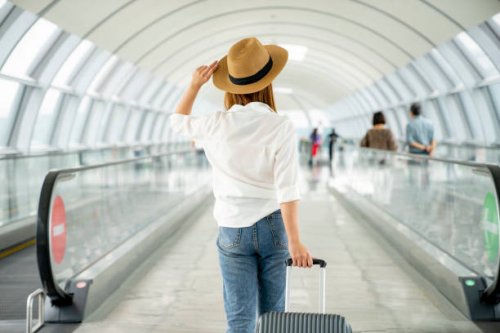 young casual female traveler with suitcase at airport - travel stock pictures, royalty-free photos & images