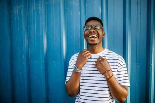 young, cheerful black man on blue door background - fashion stock pictures, royalty-free photos & images