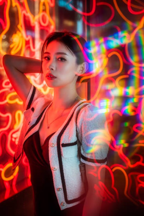 young chinese woman standing next to red neon lights - fashion stock pictures, royalty-free photos & images
