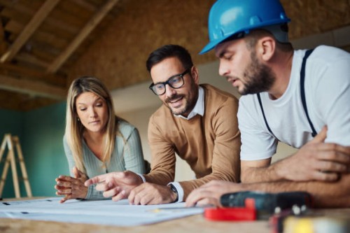 young couple analyzing blueprints with their construction worker/ - home decoration stock pictures, royalty-free photos & images