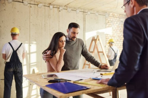 young couple analyzing housing project with their agent at construction site. - home decoration stock pictures, royalty-free photos & images
