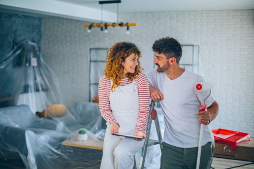 young couple choosing paint color from samples for new home interior design - home decoration stock pictures, royalty-free photos & images