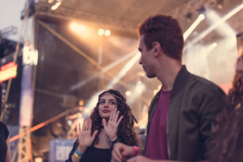young couple dancing in front of the stage at music festival - concert stock pictures, royalty-free photos & images