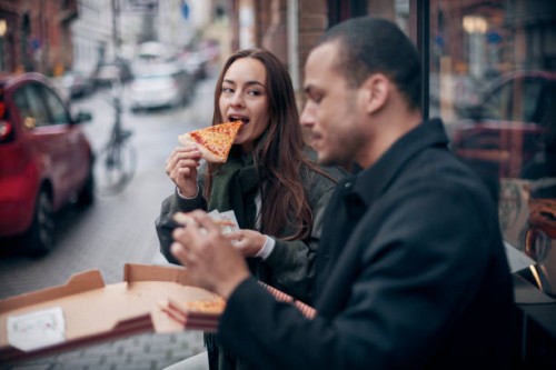 young couple eating pizza from box in the city - junk food stock pictures, royalty-free photos & images