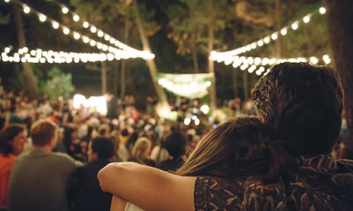 young couple embracing at night music festival - concert stock pictures, royalty-free photos & images