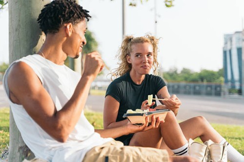 young couple enjoying a healthy meal outdoors in barcelona - junk food stock pictures, royalty-free photos & images