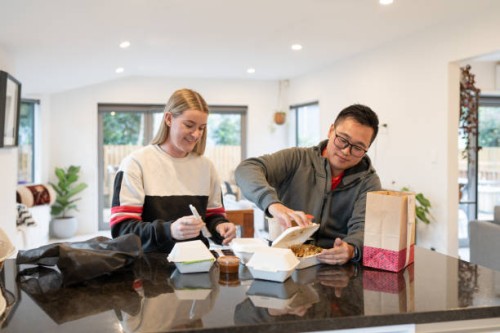 young couple enjoying delivery food at home - junk food stock pictures, royalty-free photos & images