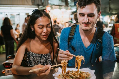 young couple having dinner together at the night market - food stock pictures, royalty-free photos & images
