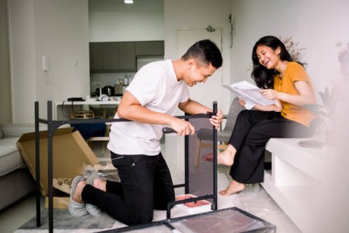 young couple helping each other assembling table - home decoration stock pictures, royalty-free photos & images