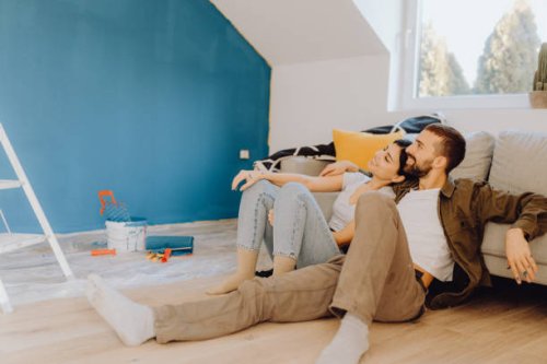 young couple paint together a wall in their apartment - home decoration stock pictures, royalty-free photos & images