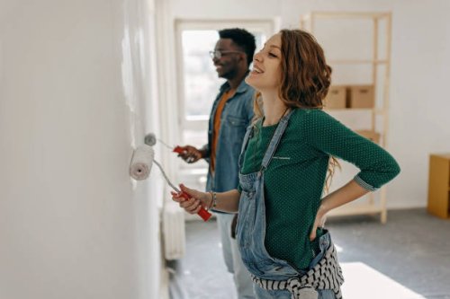 young couple painting walls - home decoration stock pictures, royalty-free photos & images
