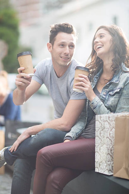young couple relaxing with coffee to go - junk food stock pictures, royalty-free photos & images