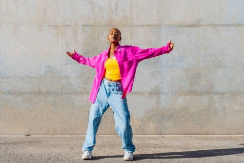 young dancer with arms outstretched in front of wall - fashion stock pictures, royalty-free photos & images