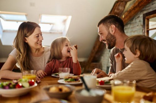 young family talking during breakfast at dining table. - food stock pictures, royalty-free photos & images