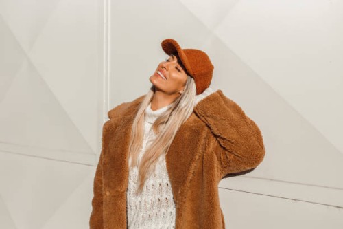 young fashionable woman wearing a fake fur coat and a cap - fashion stock pictures, royalty-free photos & images