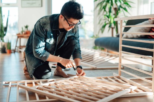 young father assembling baby cot at home - home decoration stock pictures, royalty-free photos & images