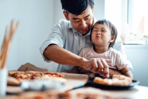 young father feeding food for his baby daughter at the table - junk food stock pictures, royalty-free photos & images