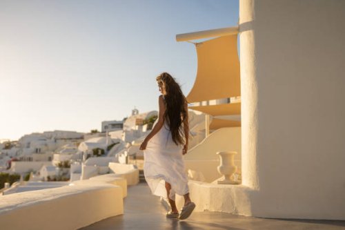 young female asian woman with white dress on a vacation in santorini, enjoying the view of the traditional architecture - travel stock pictures, royalty-free photos & images