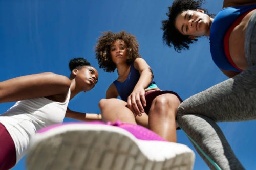 young female athletes in sportswear against blue sky - fashion stock pictures, royalty-free photos & images