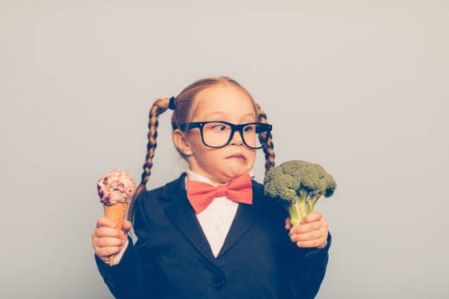 young female nerd holds ice cream and broccoli - junk food stock pictures, royalty-free photos & images