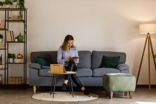 young female student sitting on the sofa and studying for exam at the university - home decoration stock pictures, royalty-free photos & images