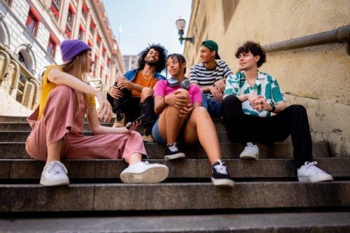 young friends talking sitting on a staircase outdoors - fashion stock pictures, royalty-free photos & images