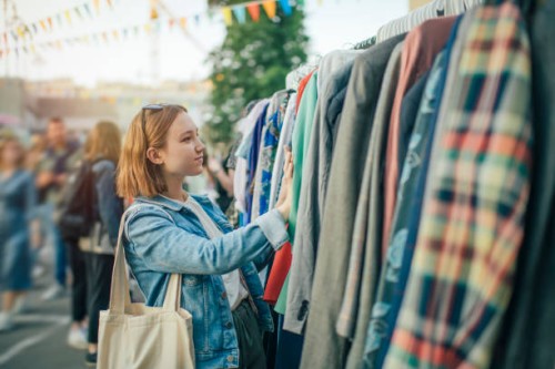 young girl choosing clothes in a second hand market in summer, zero waste concept - fashion stock pictures, royalty-free photos & images