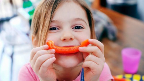 young girl smiling with pepper - food stock pictures, royalty-free photos & images
