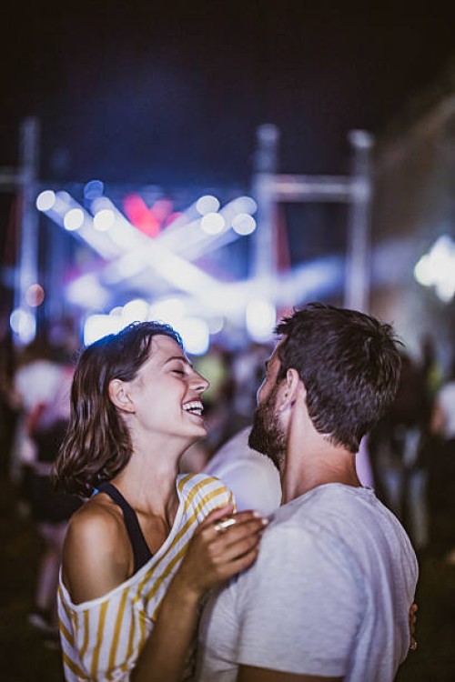 young happy couple having fun on music concert at night. - concert stock pictures, royalty-free photos & images